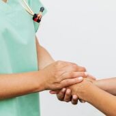 Enfermera dando la mano a un paciente