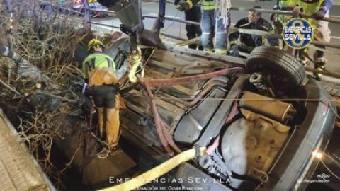 Momento del rescate por parte de los bomberos del coche que quedó suspendido en un canal en la Avenida de las Ciencias