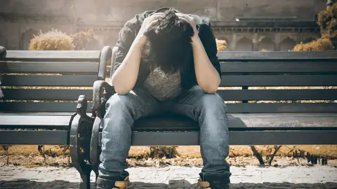 Una persona sentada en un banco Una persona sentada en un banco