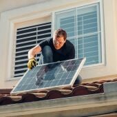 Imagen de archivo de un hombre instalando placas solares