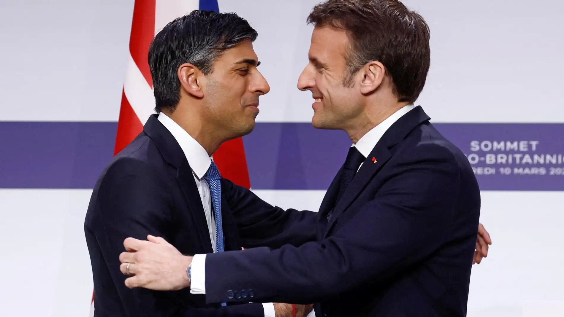 El presidente francés, Emmanuel Macron, y el primer ministro británico, Rishi Sunak, se abrazan en una rueda de prensa 