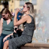 En la imagen, dos jóvenes se refrescan en una fuente del centro de la ciudad de Valencia.