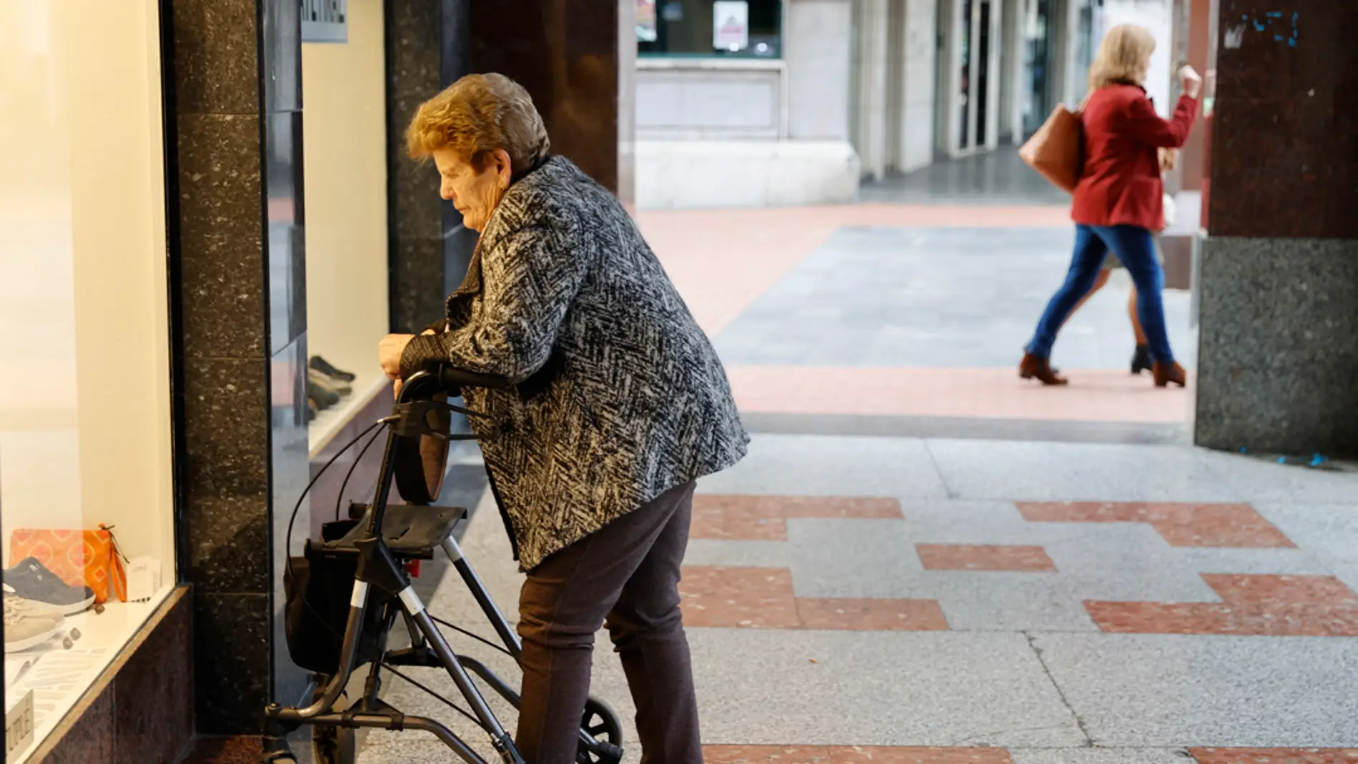 Una pensionista observa un escaparate/ EFE/Luis Tejido