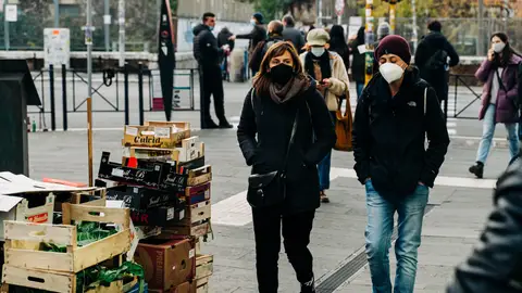 Varias personas pasean con mascarilla en una fotografía de archivo. Varias personas pasean con mascarilla en una fotografía de archivo.