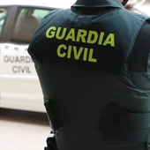 Un agente de la Guardia Civil, de espaldas, junto a un vehículo oficial Un agente de la Guardia Civil, de espaldas, junto a un vehículo oficial