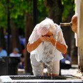 Una mujer se refresca en una fuente de Córdoba debido al calor sofocante más propio del mes de julio