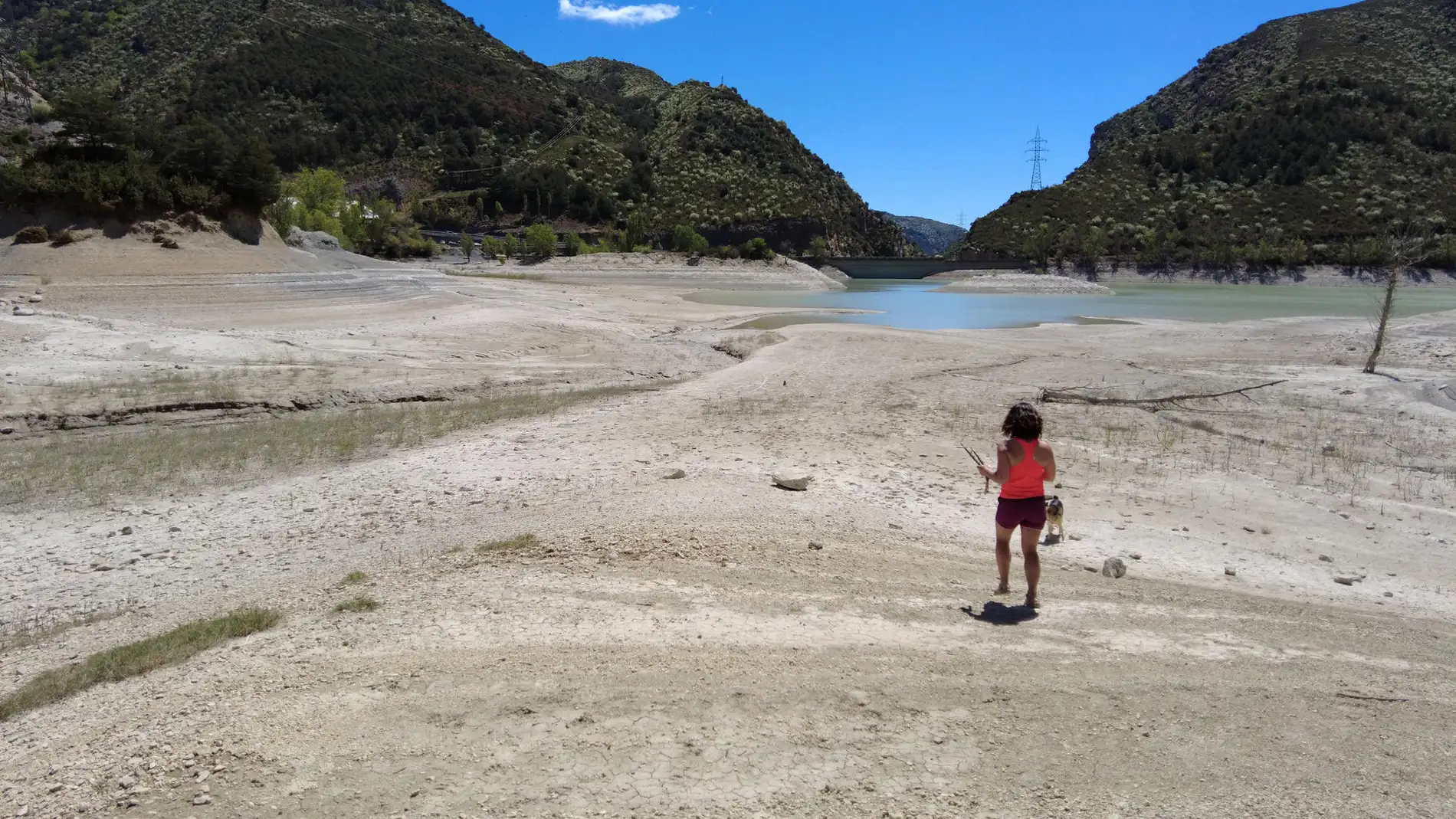 Una niña juega con su perro en el pantano de Arguis.