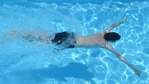 Hombre nadando en una piscina
