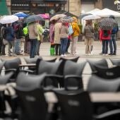 Un grupo de turistas se protege de la lluvia con sus paraguas en el centro de Vitoria este martes