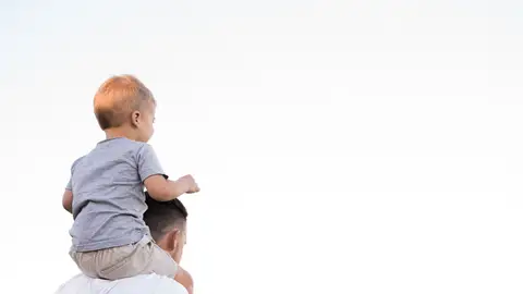 Imagen de archivo de un padre sujetando a su hijo en hombros Imagen de archivo de un padre sujetando a su hijo en hombros