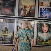 Una señora mayor frente a la cartelera de unos cines