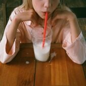 Una niña bebiendo un vaso leche