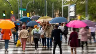 Personas caminando con paraguas por la calle