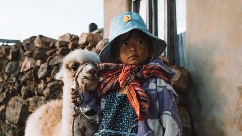 Niña con llama en Bolivia