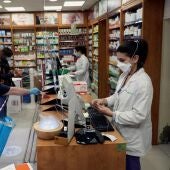 Dos personas son atendidas en una farmacia de Madrid. 
