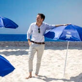 Borja Sémper posa sobre la arena y apoyado en una sombrilla