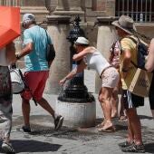 Varias personas se refrescan en fuentes del centro de Sevilla