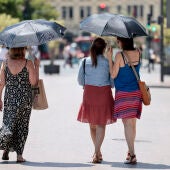 Tres mujeres se protegen del calor con unos paraguas