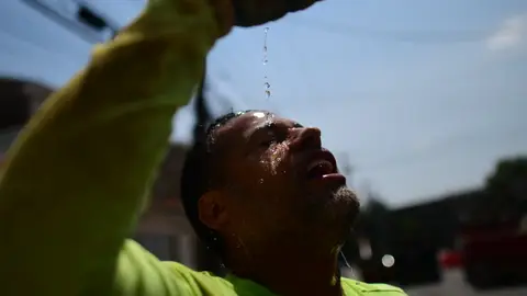 Un hombre se hidrata para combatir las altas temperaturas Un hombre se hidrata para combatir las altas temperaturas
