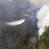 Un helicóptero vierte agua sobre el bosque incendiado en La Palma