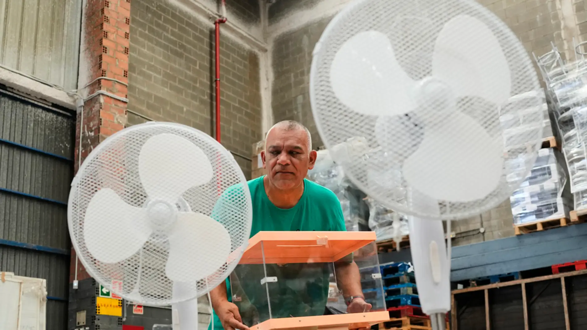 Un operario traslada urnas y ventiladores en los talleres municipales de Barcelona donde se está preparando el dispositivo para las próximas Elecciones Generales del 23J/ EFE/Alejandro García