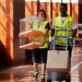Personas transportando urnas electorales