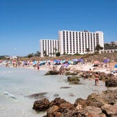 Varias personas difrutan de un día soleado en una playa de Menorca