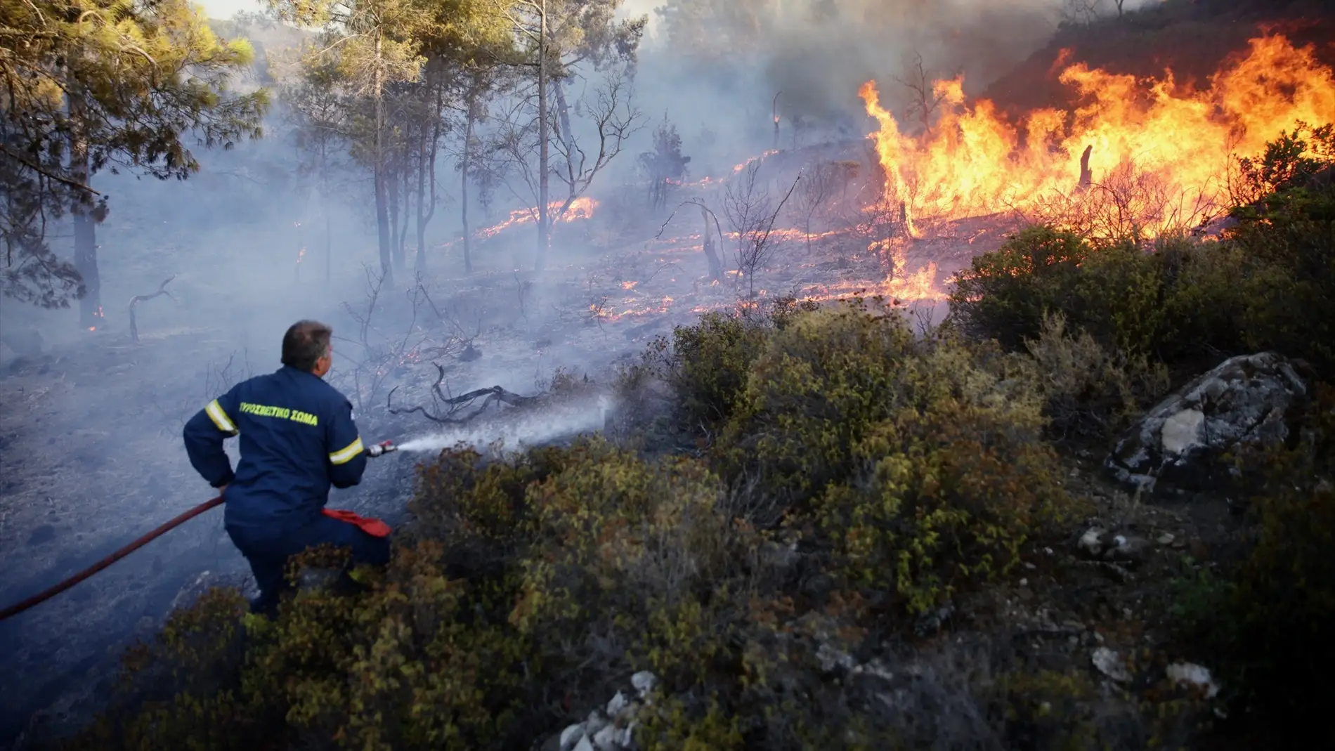 Un bombero trata de controlar el incendio que arrasa la isla griega de Rodas