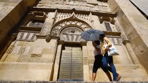 Dos turistas se protegen con un paraguas de las altas temperaturas junto a la mezquita-catedral de Córdoba. Dos turistas se protegen con un paraguas de las altas temperaturas junto a la mezquita-catedral de Córdoba.