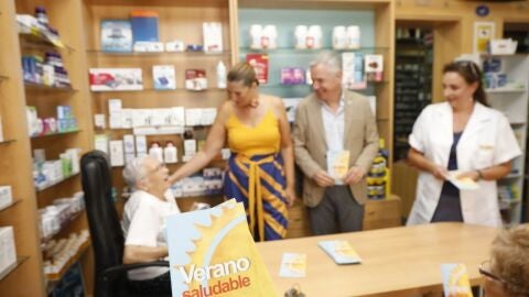Los farmac&eacute;uticos aconsejan a una mujer mayor en su oficina de farmacia