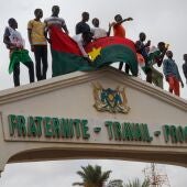 Manifestantes se paran en lo alto de la entrada a la Asamblea Nacional durante un mitin en Niamey, Níger