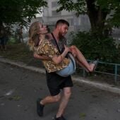 Un hombre carga a una mujer ucraniana herida tras la explosión de un segundo cohete en la ciudad de Pokrovsk.