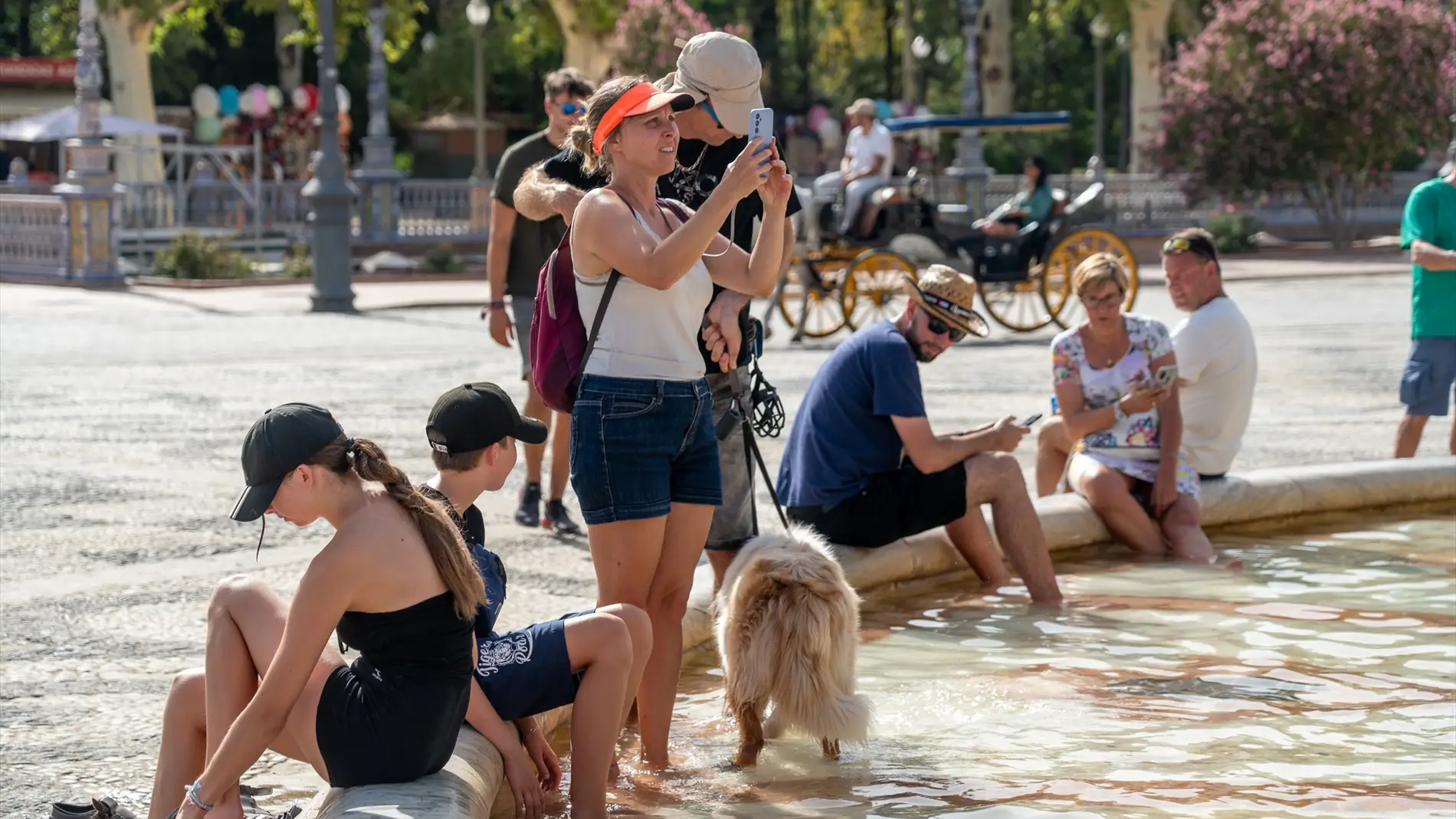 Turistas se refrescan en la Plaza de España (Sevilla)