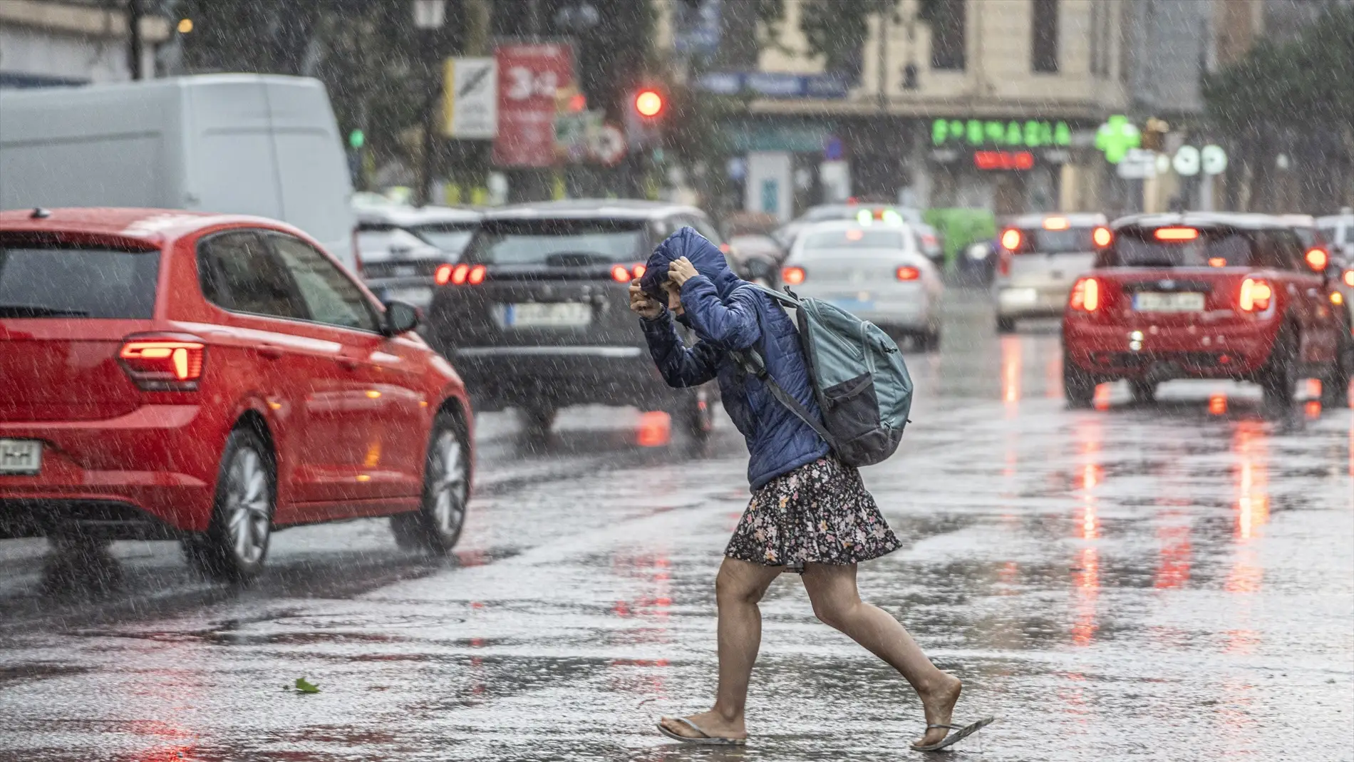 Una mujer anda por la calle bajo la lluvia.