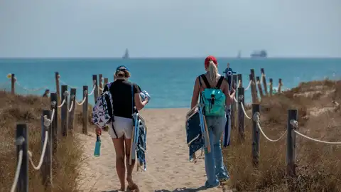 Dos personas se dirigen a la playa de El Saler. Dos personas se dirigen a la playa de El Saler.