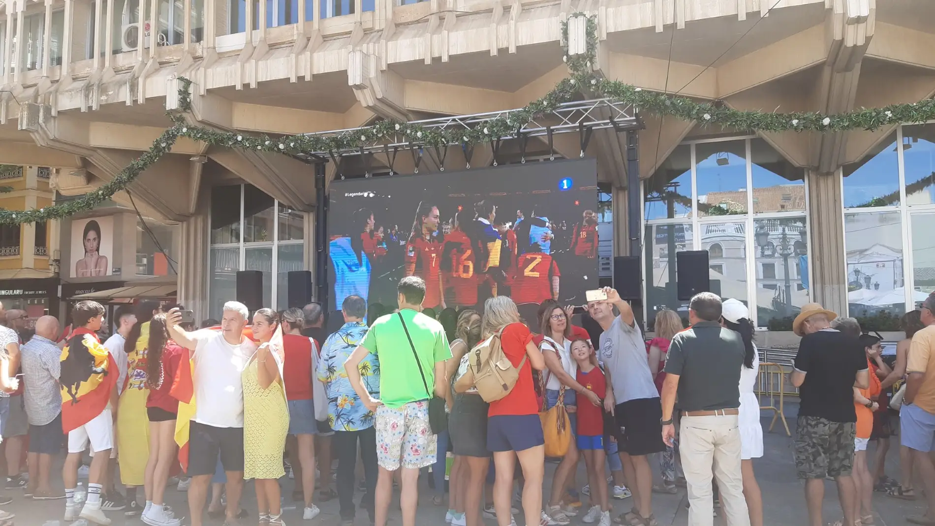 Aficionados presenciando el partido en la pantalla de la Plaza Mayor