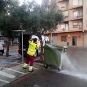 Un trabajador limpiando uno de los contenedores del casco urbano de Villena. 