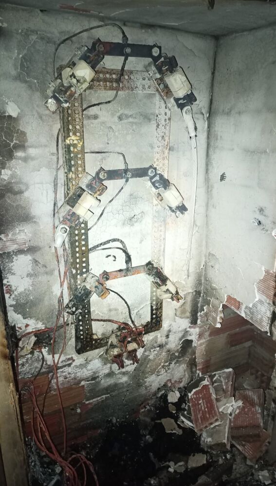 Estado en el que quedó el cuadro de luz del zaguán quemado en un edificio del Raval