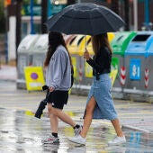  Dos chicas caminan por la calle bajo un paraguas este domingo en Ibiza.