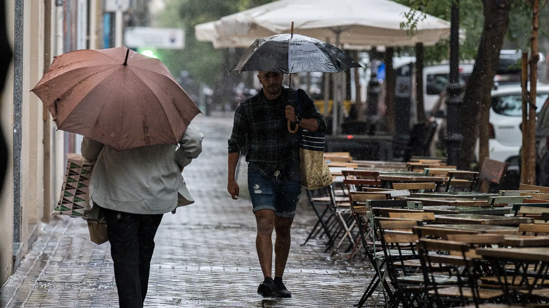 Varias personas se resguardan de la lluvia durante la DANA en Madrid