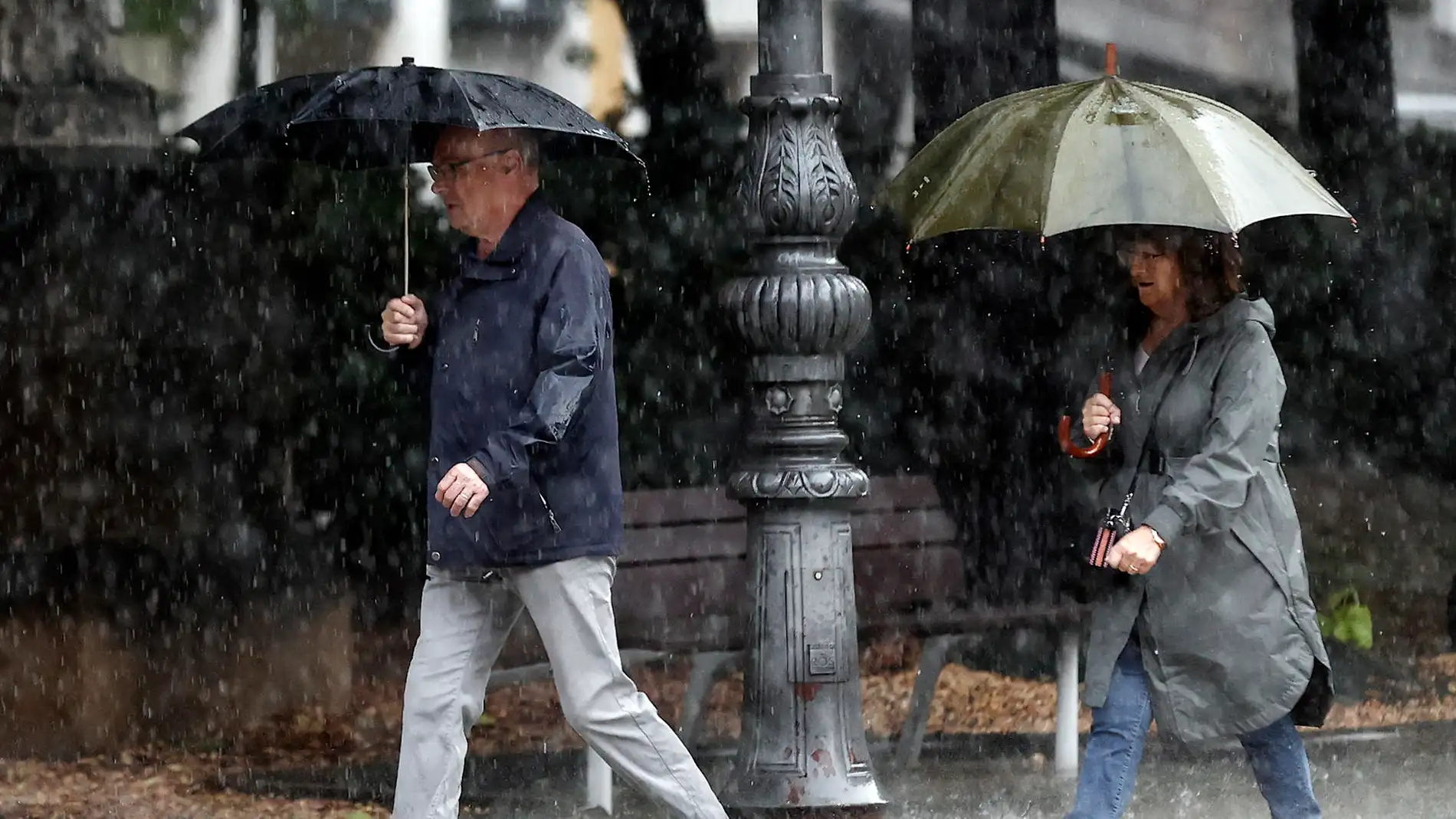 Dos personas se protegen de la lluvia con sus paraguas