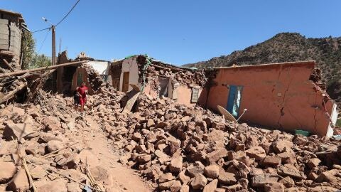 Los ni&ntilde;os caminan entre los escombros de edificios da&ntilde;ados tras un potente terremoto en la aldea de Tinmel, al sur de Marrakech, Marruecos