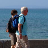 Dos personas mayores paseando por la playa