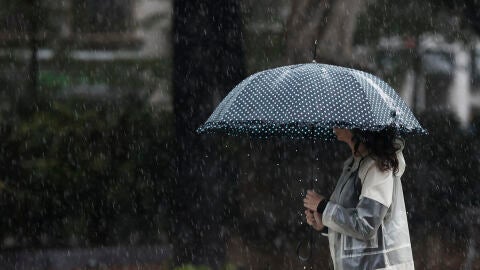 Una mujer protegiéndose de la lluvia con un paraguas