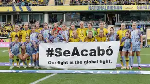 Las jugadoras de España y Suecia posan con una pancarta en la que se lee "Se Acabo, nuestra lucha es global".