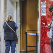 Archivo - Un joven mira su teléfono móvil mientras espera para entrar en una oficina de empleo en València. Archivo - Un joven mira su teléfono móvil mientras espera para entrar en una oficina de empleo en València.