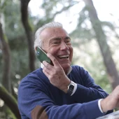 Imagen de archivo de un hombre usando su ordenador y teléfono móvil Imagen de archivo de un hombre usando su ordenador y teléfono móvil