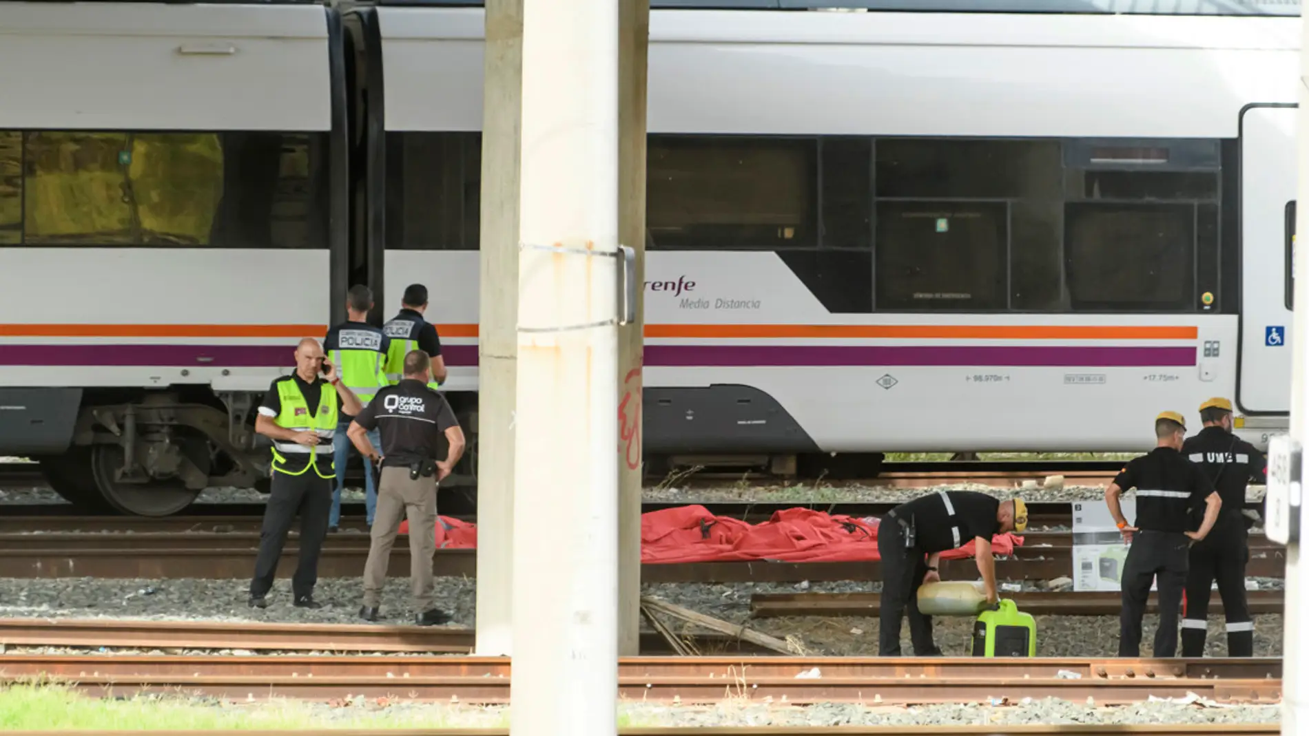Agentes de Policía, de la UME y de seguridad de Renfe junto al cuerpo hallado entre dos vagones de un tren en la estación de Santa Justa 