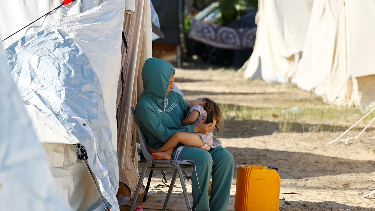 Una mujer palestina con su hijo en un campamento de refugiados en Gaza