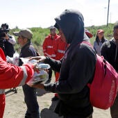Una paramédica de la Cruz Roja, entrega alimentos a migrantes centroamericanos